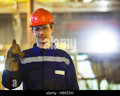 I lavoratori e i montatori saldatori in abbigliamento protettivo e un casco. Lavorando in esercizio impianti industriali. Foto Stock