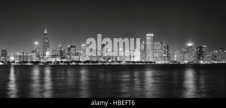 Bianco e nero foto panoramiche di Chicago skyline della città con la riflessione nel lago Michigan di notte. Foto Stock