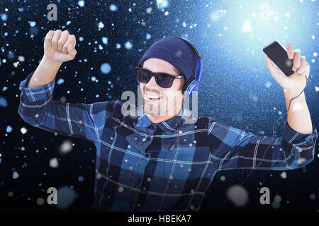 Immagine composita di felice hipster indossando le cuffie ascoltare musica Foto Stock