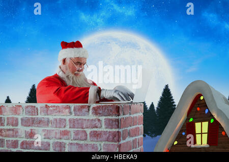 Immagine composita di santa claus utilizzando laptop sul camino Foto Stock