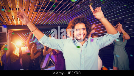 Immagine composita del gruppo di sorridere amici ballare sulla pista da ballo Foto Stock