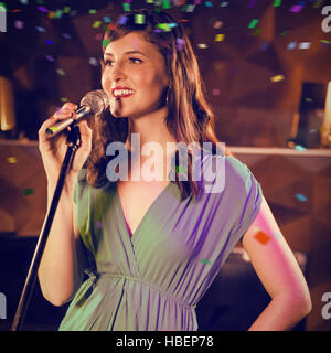 Immagine composita della donna cantare in bar Foto Stock