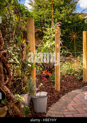 Le aree giardino diviso utilizzando i paletti di legno per creare stanze esterne in design moderno e contemporaneo Foto Stock