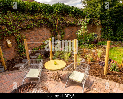 Le aree giardino diviso utilizzando i paletti di legno per creare stanze esterne in design moderno e contemporaneo Foto Stock