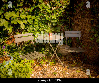 Il Bistro area con posti a sedere nel giardino del Regno Unito con tavolo e due sedie Foto Stock