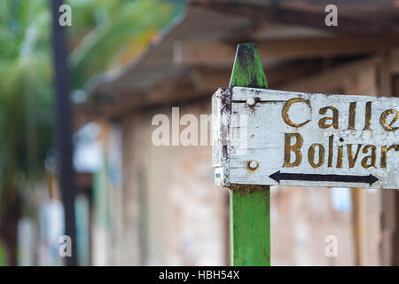 Sbiadito cartello in legno con frecce per la Calle Bolivar in Bolivia Foto Stock