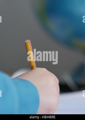 Le mani del bambino iscritto nella parte anteriore del globo Foto Stock