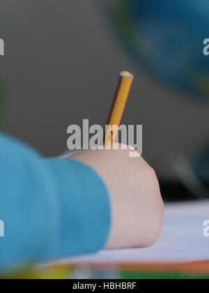 Le mani del bambino iscritto nella parte anteriore del globo Foto Stock