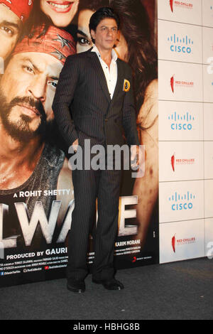 Shah Rukh Khan in piedi con mano in tasca, attore indiano Bollywood di fronte al poster del film Dilwale a Mumbai, India Foto Stock