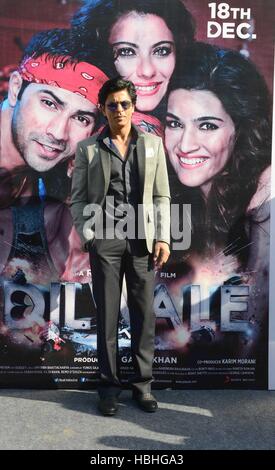 L'attore Bollywood Shah Rukh Khan si trova di fronte al film Dilwale poster a Nuova Delhi, India Foto Stock