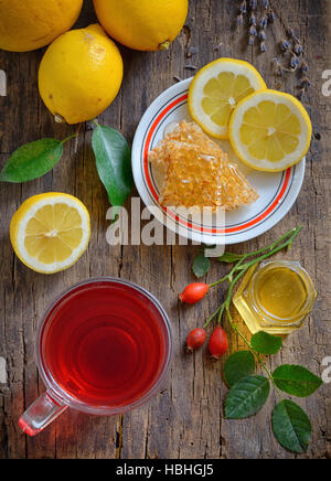 Tè con limone e miele su sfondo di legno Foto Stock