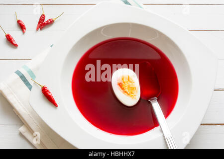 Tradizionale rosso chiaro zuppa di barbabietole - borscht - con uovo Foto Stock