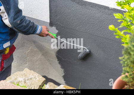 Pittore con rullo di vernice in mano Foto Stock