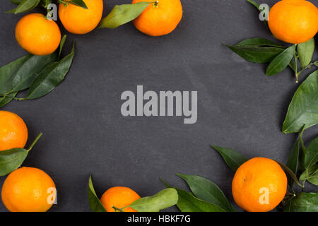 In ardesia scura con tavola tangerine frutti per lo sfondo con spazio di copia Foto Stock
