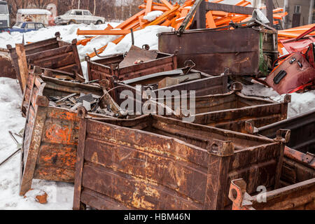 La pila di rusty scatole di metallo nella neve in inverno. Foto Stock
