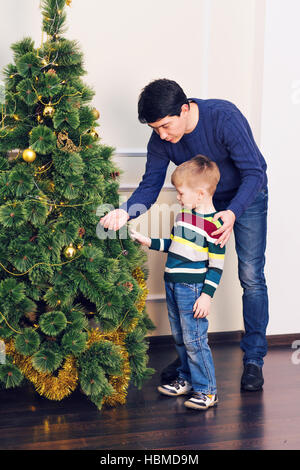 Padre e figlio sono decorare l'albero di Natale Foto Stock