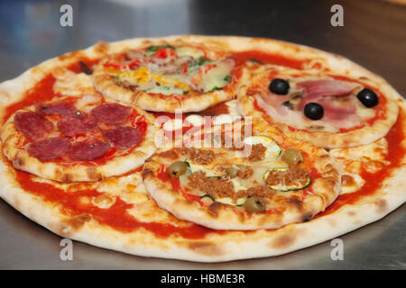 Grande pizza con quattro piccole Foto Stock