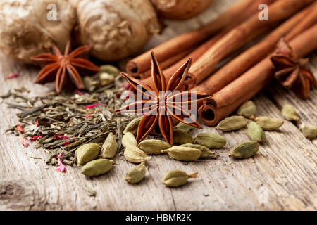 Ingredienti per preparare il tè con spezie sul vecchio sfondo di legno Foto Stock