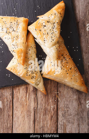 Deliziose torte filo sfoglia con pollo, spinaci e feta vicino sul tavolo. vista verticale da sopra Foto Stock