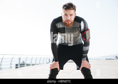 Stanco runner vicino al mare. guardando la fotocamera. vista frontale Foto Stock