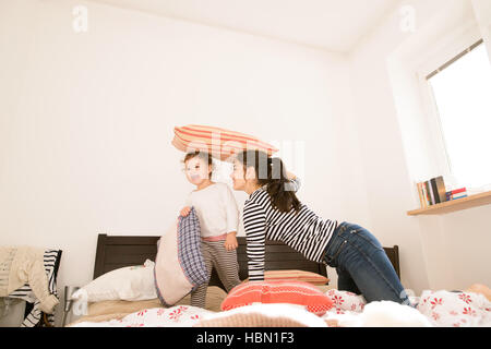 Madre divertendosi con la figlia nella sua camera da letto Foto Stock