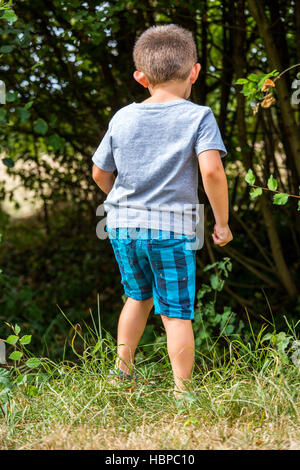 Bambino esplorando la natura al confine con la foresta Foto Stock