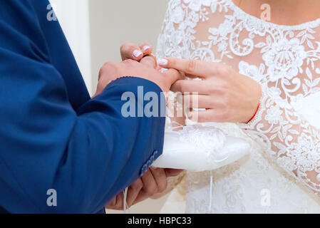 Lo sposo indossa l'anello Foto Stock