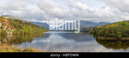 Llyn Padarn Lake nei pressi del villaggio di Llanberis e le lontane Snowdon massiccio, Parco Nazionale di Snowdonia, Gwynedd, Galles del Nord, Regno Unito Foto Stock