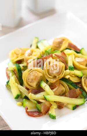 Formaggio cotto al forno tortellini o pulsante di emergenza la pasta con le zucchine, pancetta e timo, fotografati con luce naturale (messa a fuoco selettiva) Foto Stock