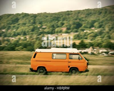 Accelerando orange T3 Volkswagen camper van vicino a Malvern Hills Worcestershire Foto Stock