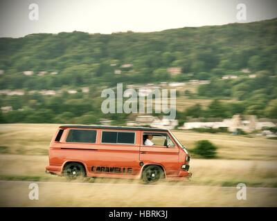 Accelerando orange T3 Volkswagen camper van vicino a Malvern Hills Worcestershire Foto Stock