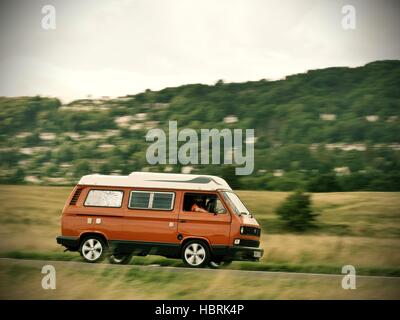 Accelerando orange T3 Volkswagen camper van vicino a Malvern Hills Worcestershire Foto Stock