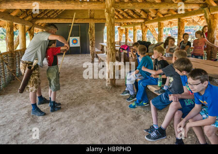 Ragazzo giovane imparare a sparare con un inchino, Carpazi Troy Open-Air archeologico museo in Trzcinica vicino a Jaslo, Malopolska, Polonia Foto Stock
