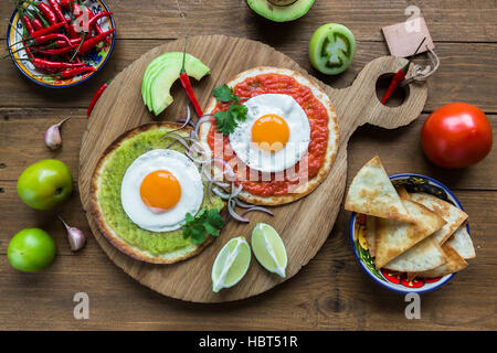 Divorziato di uova fritte su tortilla di mais con salsa verde e rossa Foto Stock