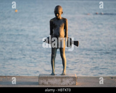 Il piccolo Pescatore"- una scultura in bronzo di un giovane ragazzo e un grande pesce, da Paphos artista, Giota Ioannidou. Foto Stock