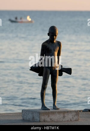 Il piccolo Pescatore"- una scultura in bronzo di un giovane ragazzo e un grande pesce, da Paphos artista, Giota Ioannidou. Foto Stock