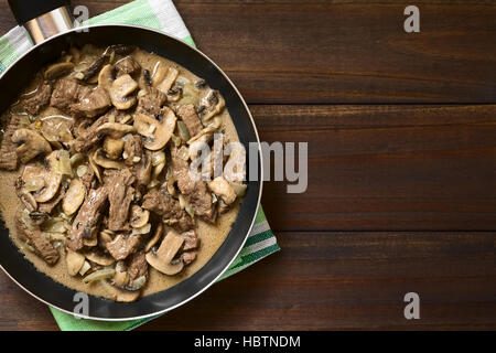 Carni bovine Stroganoff in padella, un piatto fatto di pezzi di carne di manzo, funghi e cipolla in salsa alla panna Foto Stock