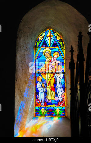 Il vetro macchiato la Madonna e il bambino nella vecchia chiesa normanna. Foto Stock