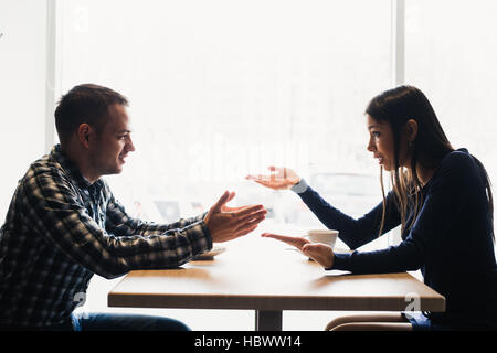 Scena in cafe - giovane conflitto sostenendo durante il pranzo. Foto Stock