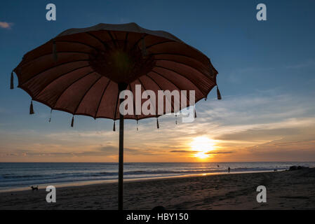 Balinese ombrellone in spiaggia durante il tramonto in spiaggia Chenggu, isola di Bali Foto Stock