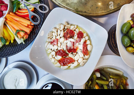 Brunch italiano, selezione di antipasti dal buffet come verdure tagliate, aglio, olive, sottaceti e salse Foto Stock