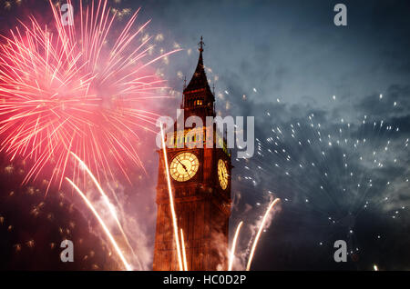 Esplosivo fuochi d'artificio riempie il cielo intorno al Big Ben. Veglione di Capodanno sfondo Foto Stock