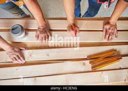 Angolo di alta vista di due falegnami di disegno su tavole di legno Foto Stock