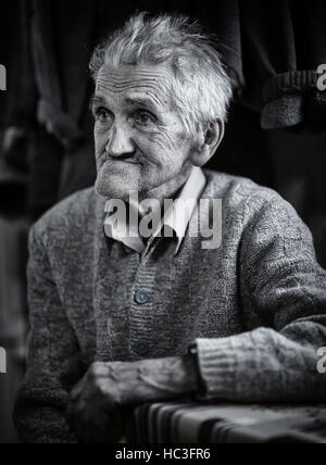 Primo piano di un vecchio uomo indoor, dai toni monocromatici Foto Stock