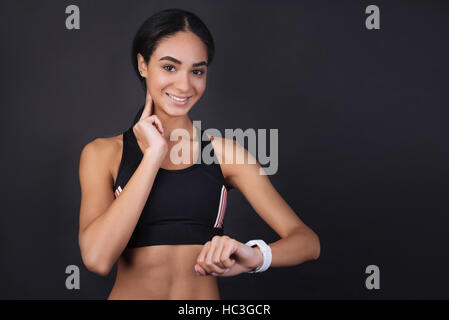 Ragazza carina misurando il suo impulso utilizzando smart orologi Foto Stock