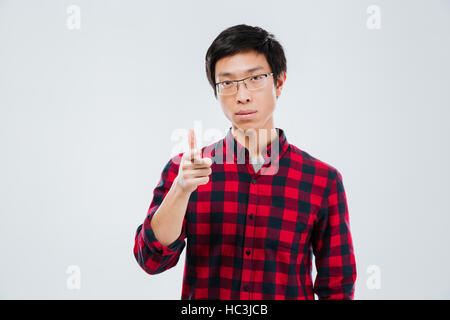 Ritratto di bel giovane vestito in camicia casual in una gabbia e indossando occhiali puntando alla fotocamera e isolate su sfondo bianco Foto Stock
