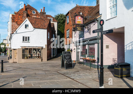 Xvi secolo "The Woolpack' coaching inn e il XV secolo corner shop. con una stretta viuzza tra loro. Segnaletica turistica. High street, Tenterden. Foto Stock