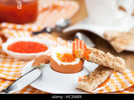 Uova sode con caviale rosso, pane tostato e caffè per colazione Foto Stock