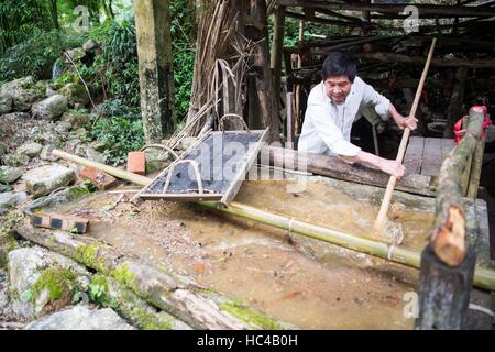 (161208) -- CHONGQING, 8 dicembre, 2016 (Xinhua) -- Li Shilin suscita materiali per la fabbricazione della carta in città Xinglong, a sud-ovest della Cina di Chongqing, Giugno 7, 2016. Li la famiglia, vivendo in Xinglong città di Chongqing ha tramandato l'artigianato tradizionale di rendere "Tuhuo' carta attraverso cinque generazioni. "Tuhuo' carta, fatto di bambù che cresce in aree locali, richiede elevati standard di tecniche attraverso tutte le fasi di lavorazione. Tuttavia, ad alta intensità di manodopera, scarse vendite e bassi rendimenti, l'imbarcazione viene ereditato da alcuni giovani, che ha spinto il governo a sviluppare come un progetto di turismo in una Foto Stock