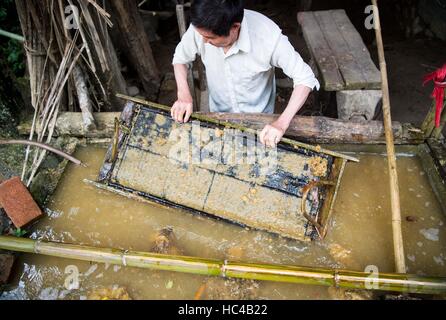 (161208) -- CHONGQING, 8 dicembre, 2016 (Xinhua) -- Li Shilin rende 'Tuhuo' carta Xinglong in città, a sud-ovest della Cina di Chongqing, Giugno 7, 2016. Li la famiglia, vivendo in Xinglong città di Chongqing ha tramandato l'artigianato tradizionale di rendere "Tuhuo' carta attraverso cinque generazioni. "Tuhuo' carta, fatto di bambù che cresce in aree locali, richiede elevati standard di tecniche attraverso tutte le fasi di lavorazione. Tuttavia, ad alta intensità di manodopera, scarse vendite e bassi rendimenti, l'imbarcazione viene ereditato da alcuni giovani, che ha spinto il governo a sviluppare come un progetto del turismo in un obiettivo di fischi Foto Stock